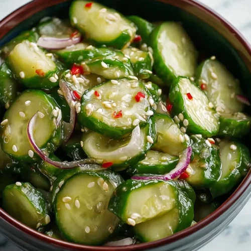 Spicy Cucumber Salad recipe in a vibrant bowl with red peppers and sesame seeds