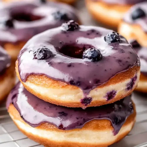 Fresh blueberry cake donuts with glaze on cooling rack