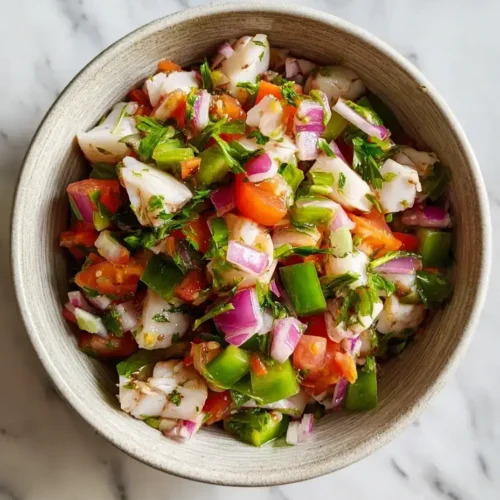 Fresh conch salad recipe served in a white bowl on marble countertop
