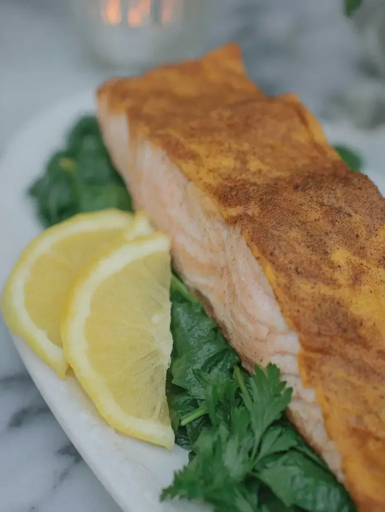 Perfectly pan-seared keto salmon fillet with lemon and dill garnish.